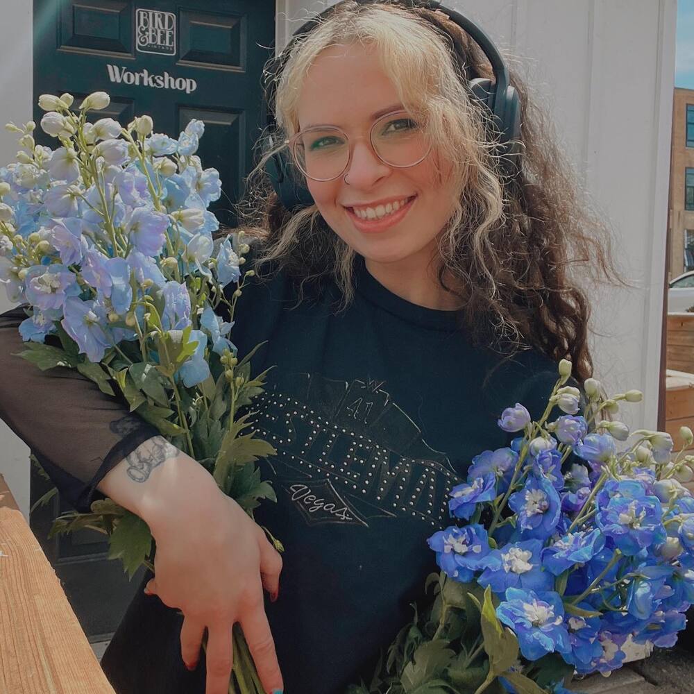 Lady holding bunch of larkspur flower Lady holding bunch of larkspur flower - July birth flower