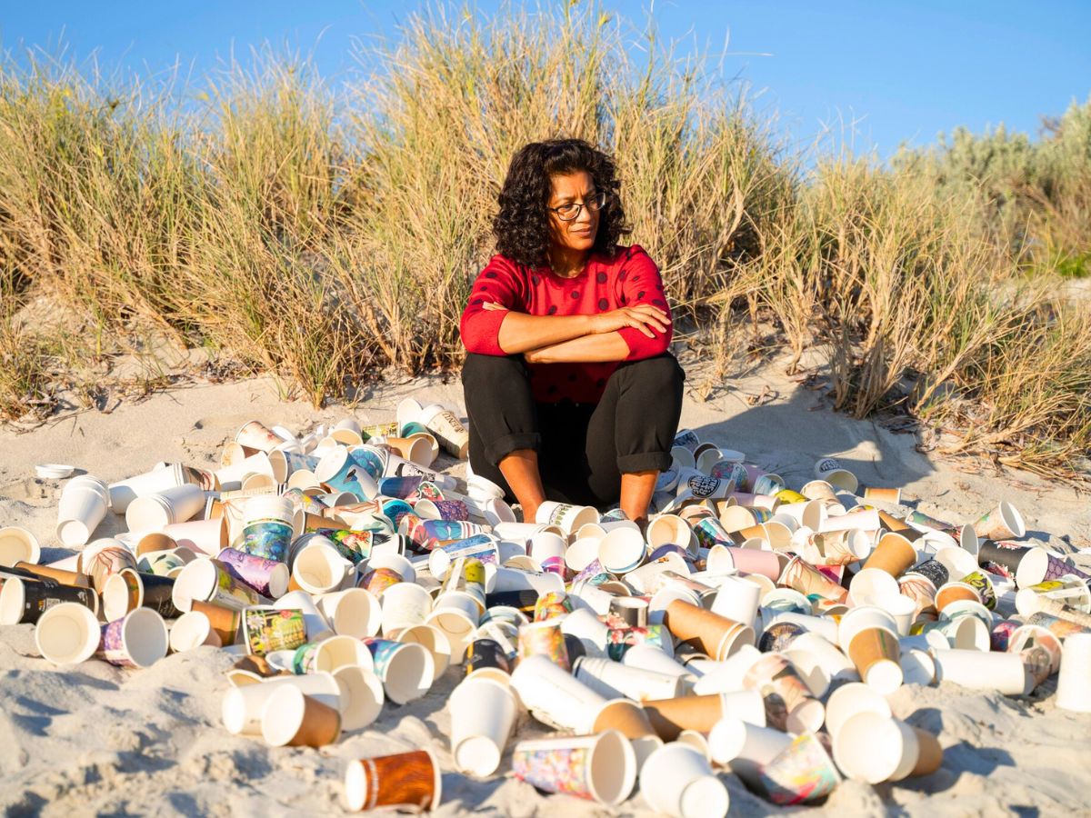 Girl on the beach with many cups
