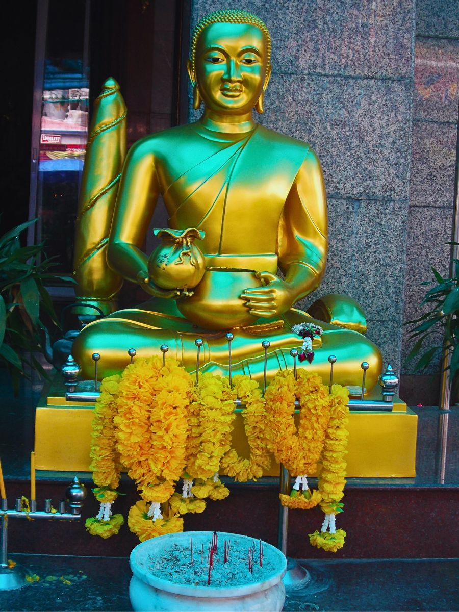 A golden statue with flowers Phuang Malai: Thailand’s Art of Making Floral Garlands