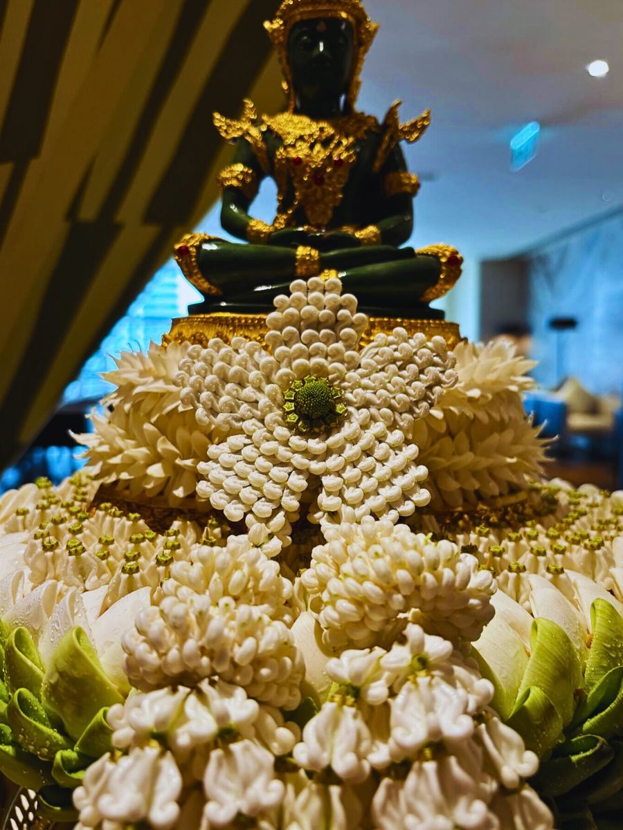 A statue surrounded with flowers Phuang Malai: Thailand’s Art of Making Floral Garlands