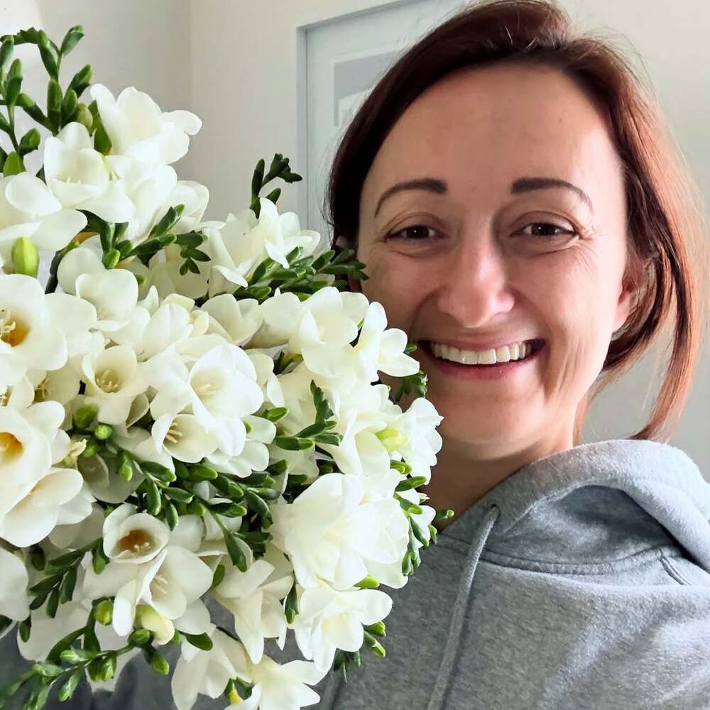 woment holding scented freesia bouquet woment holding scented freesia bouquet