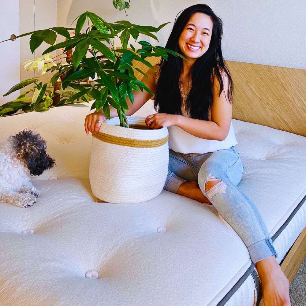 woman and her pet sitting beside a potted money tree plant
