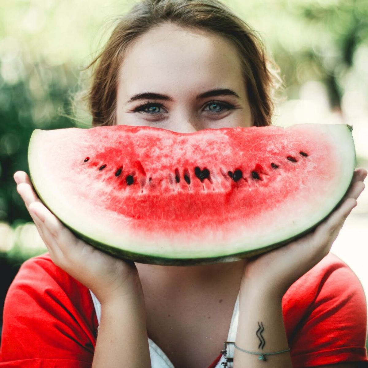A girl with blue eyes holding a watermelon A girl with blue eyes holding a watermelon