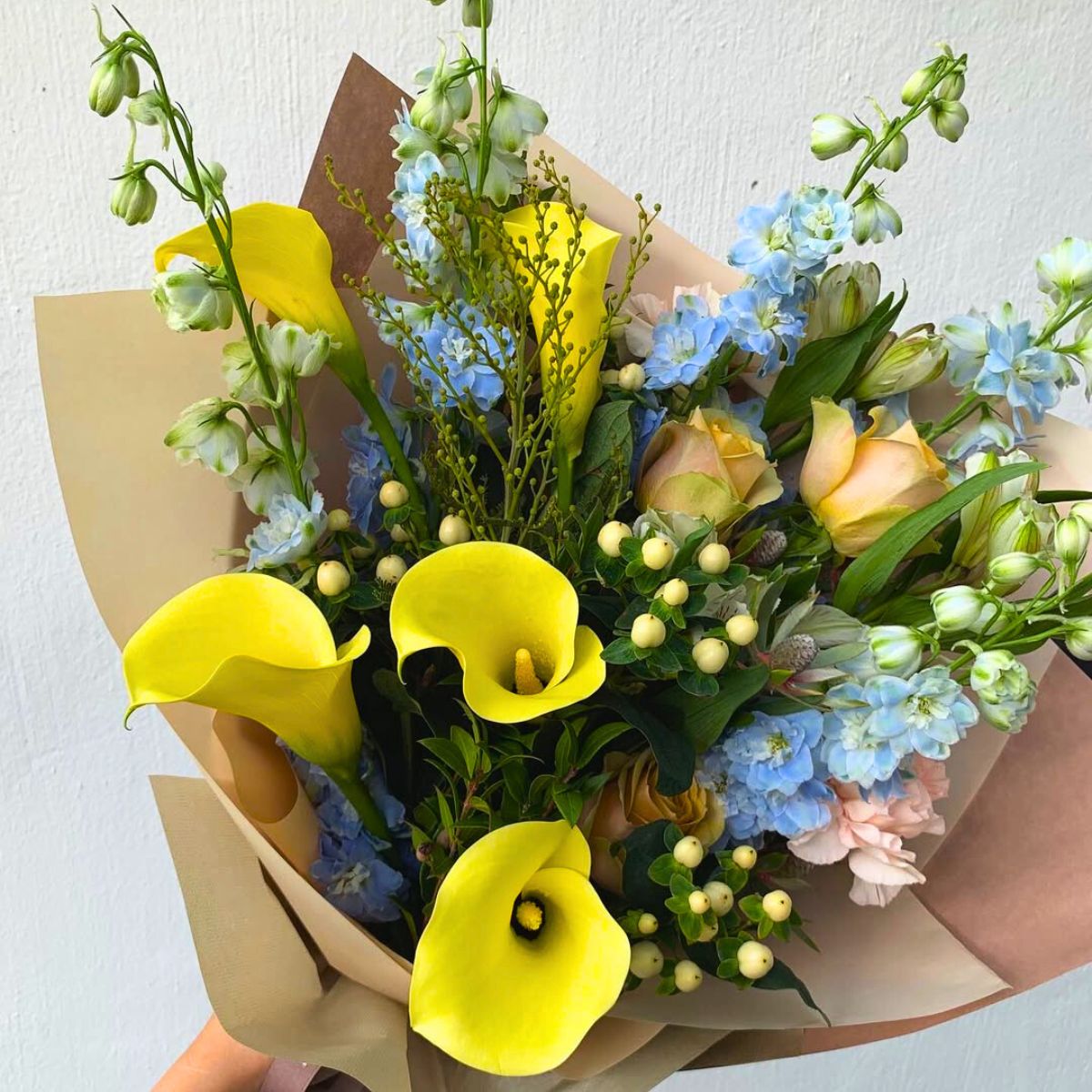 A bouquet of yellow callas and blue flowers