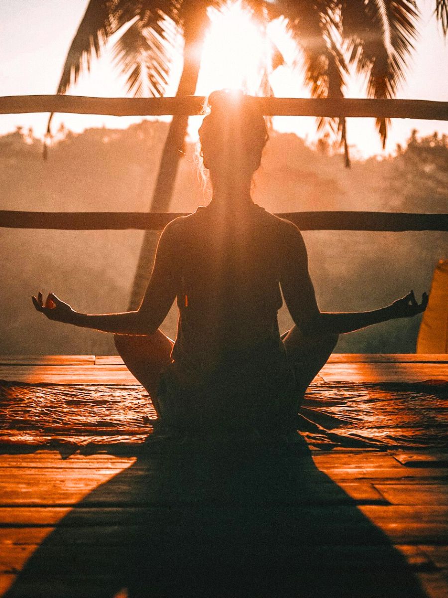 Person meditating in the sunset