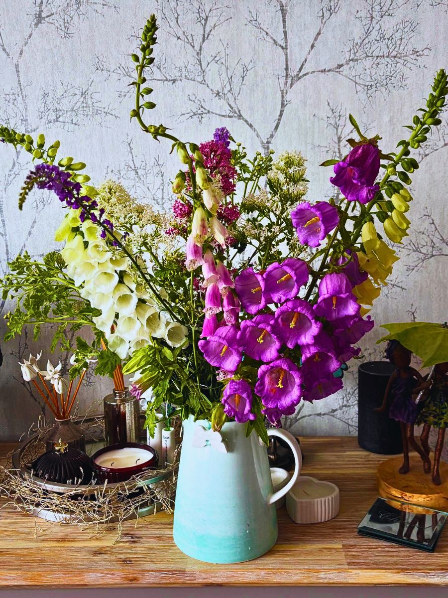 Canterbury bells design campanula medium flowers along with others paired to enhance the table centerpiece arrangement