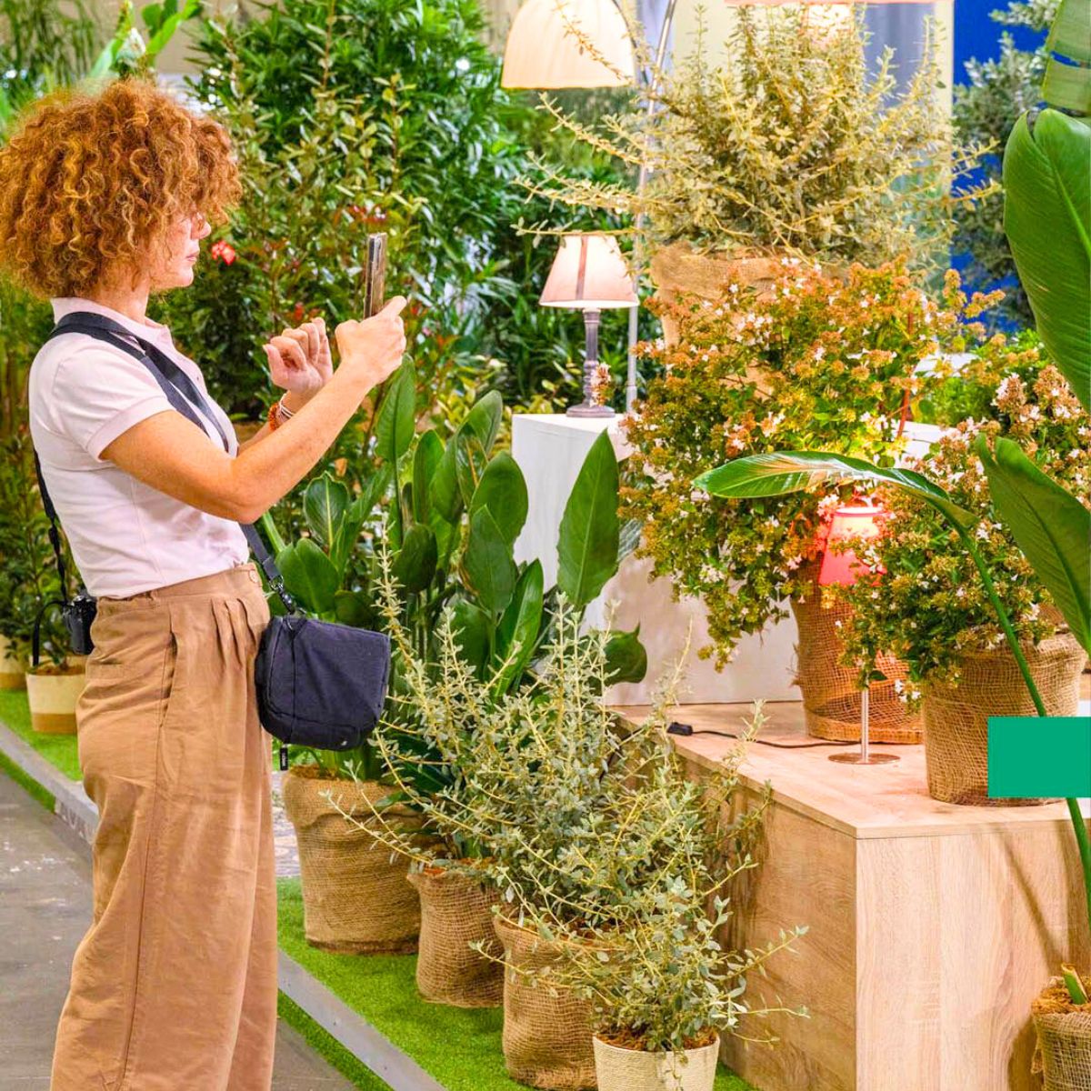A lady taking pictures of greenery at Iberflora
