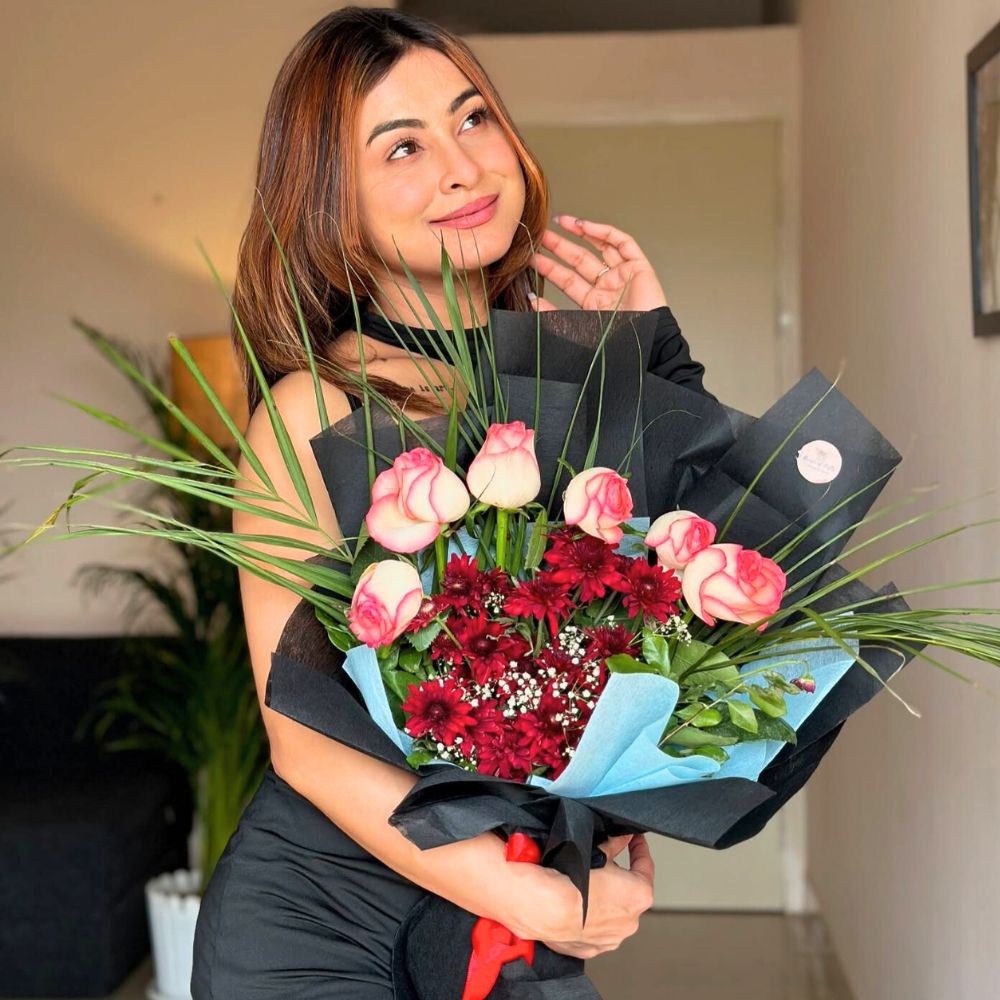 Lady poses for a picture with a colorful bouquet she received as a gift romantic devotion and innocence gleaming from these significant colorful floral beauties