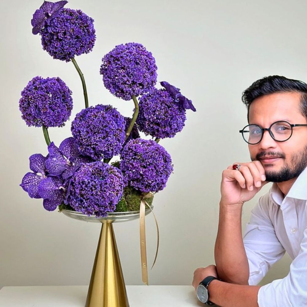 Florist Kazi poses for a picture next to his design of the purple Limonium ECHANTE from the breeder Danziger