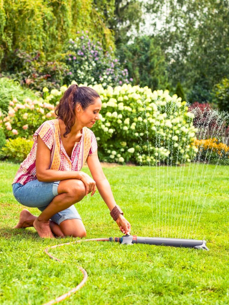 Woman placing a watering device in her garden