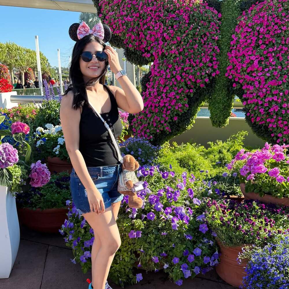 Woman posing with floral butterfly display Woman posing with floral butterfly display
