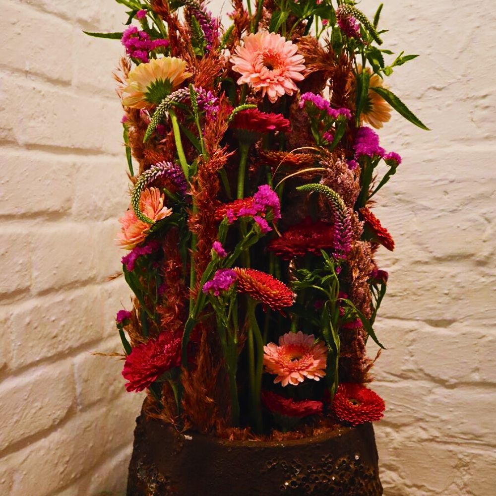 The ‘Parallel Welcome Design’ by Max Hurtaud. This masterpiece harmoniously blends the vibrant PETIT EDNA™, GENKI™, and PETIT BAR™ Gerberas with the delicate hues of SINUET™ ETERNAL PINK Limonium and the elegant SKYLER™ PINK Veronica.