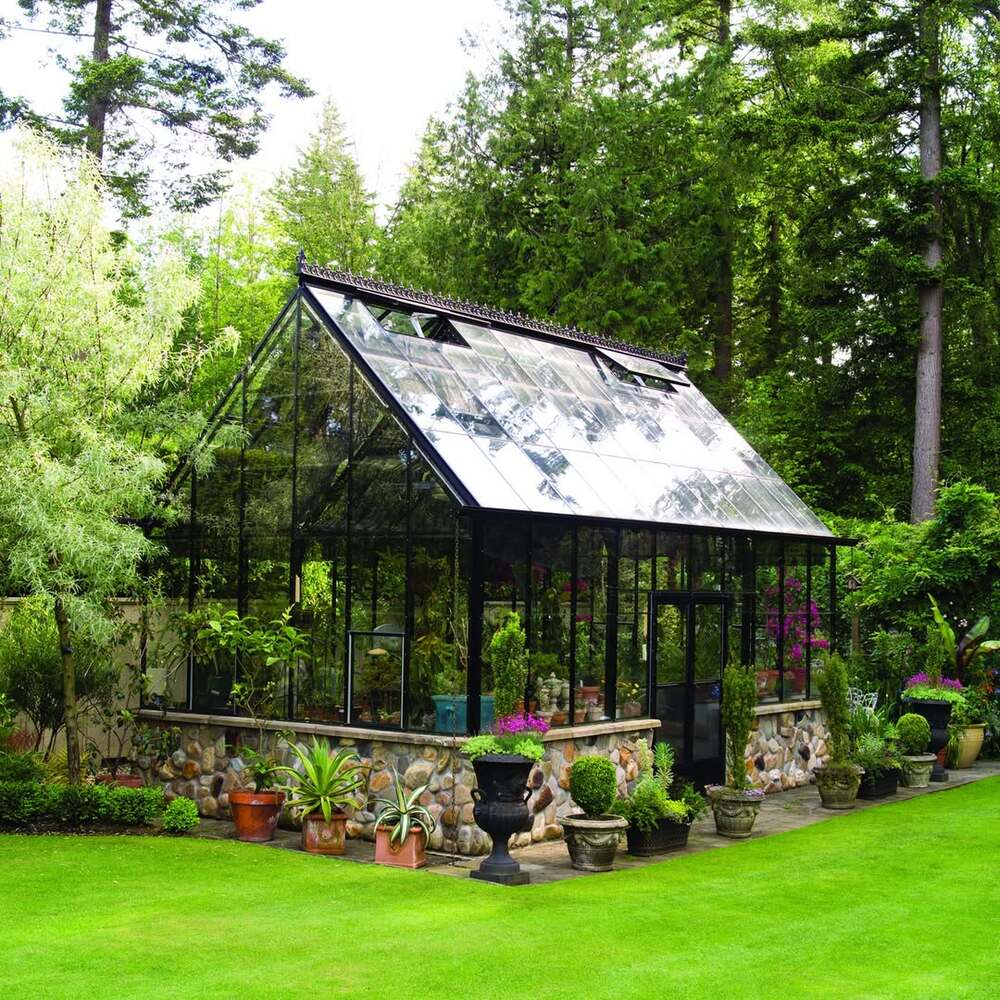 Stone-based glass greenhouse in garden