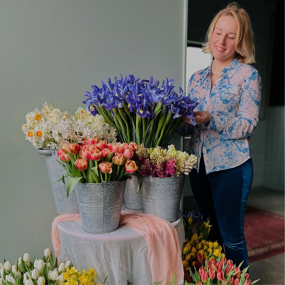 Katya Hutter admires a blue iris on a vase Blue Iris
