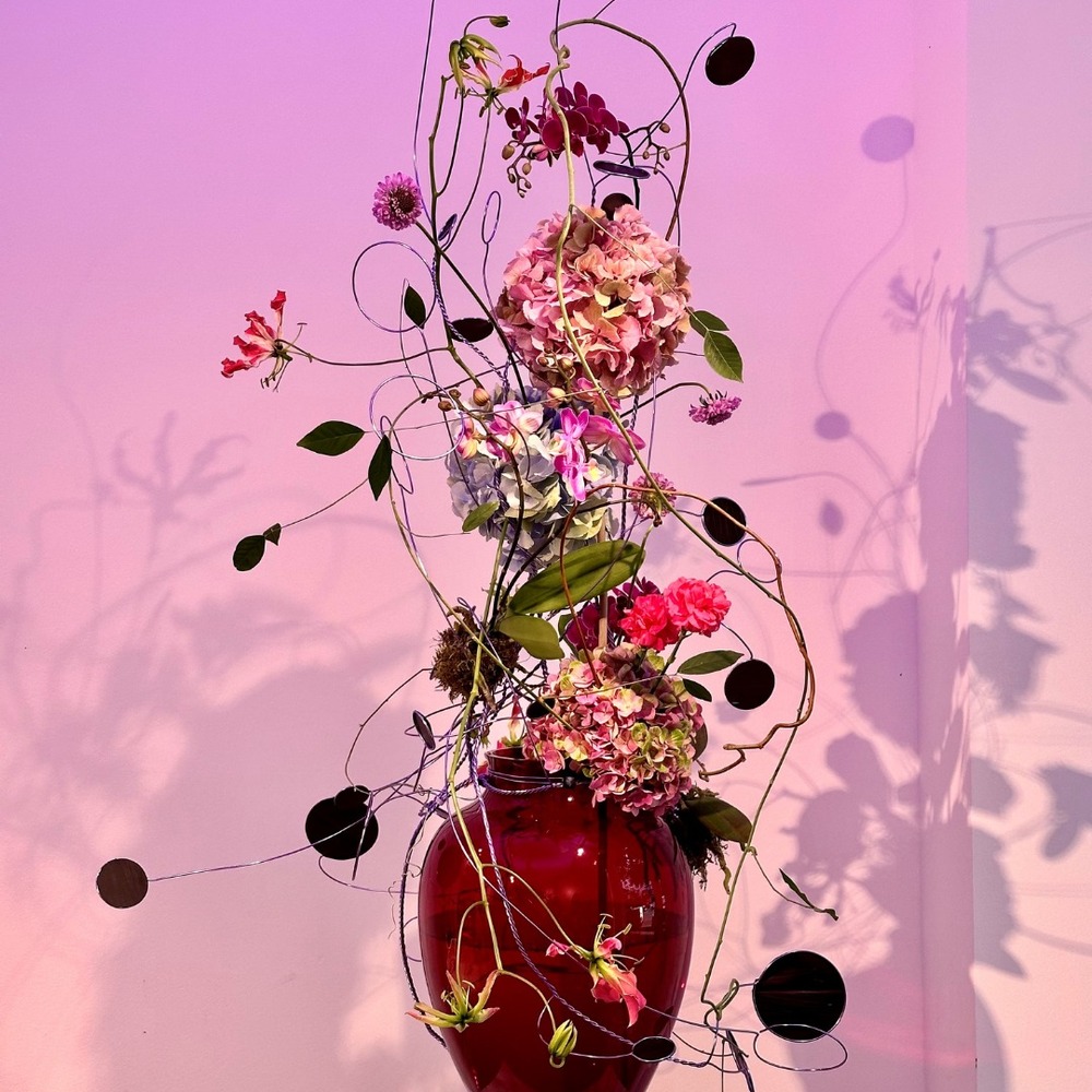 Whimsical floral sculpture in red vase