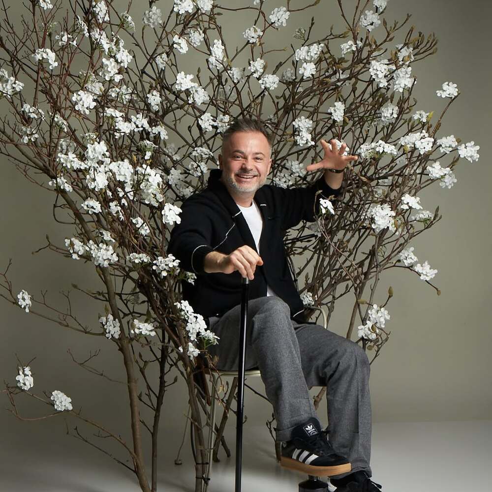 Florist sitting among white blossoms