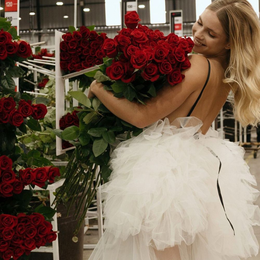 A model admires a bunch of red roses Vibrant flowers in shades of red - a model admires a bunch of red roses