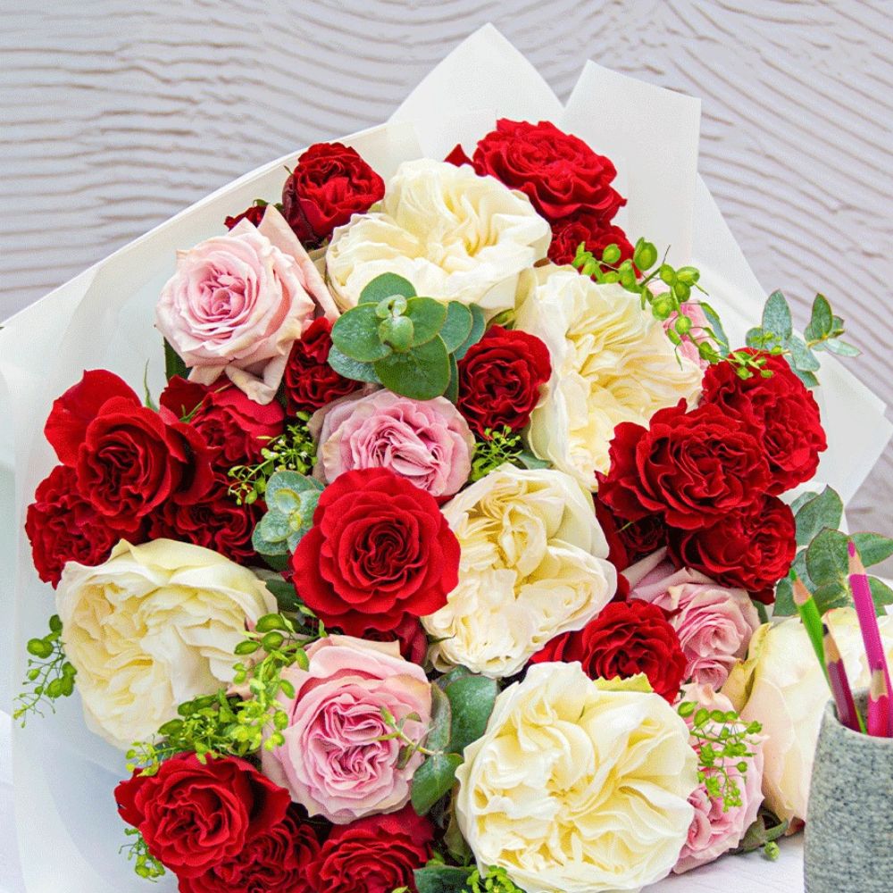 A bouquet featuring garden red roses vibrant blooms of flowers in a floral arrangement in the shades of red yellow and peach pink; Inset - a bouquet of garden red roses
