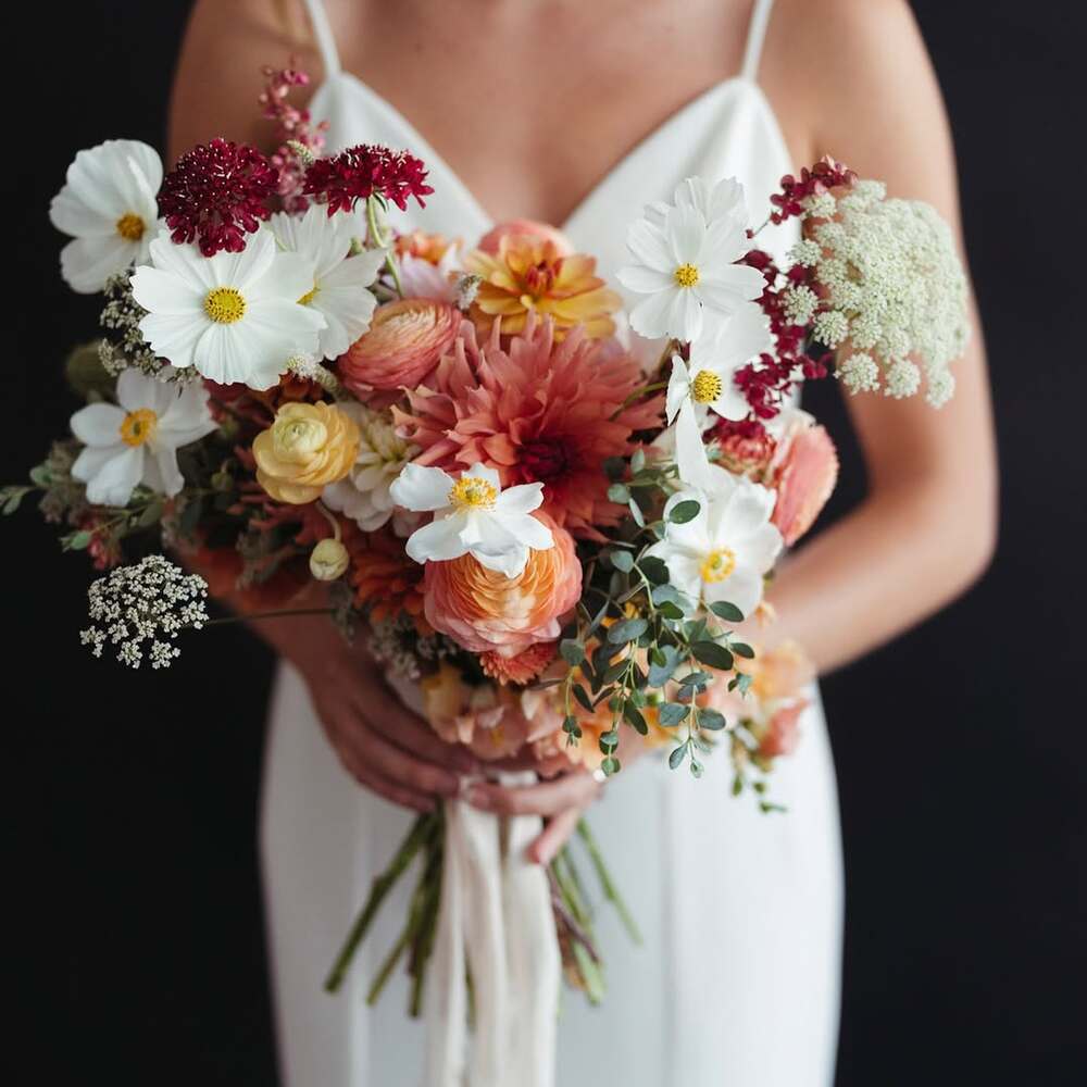 Bride holding vibrant floral bouquet