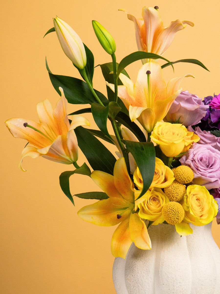 A vase filled with summer flowers and roses A vase filled with summer flowers and roses