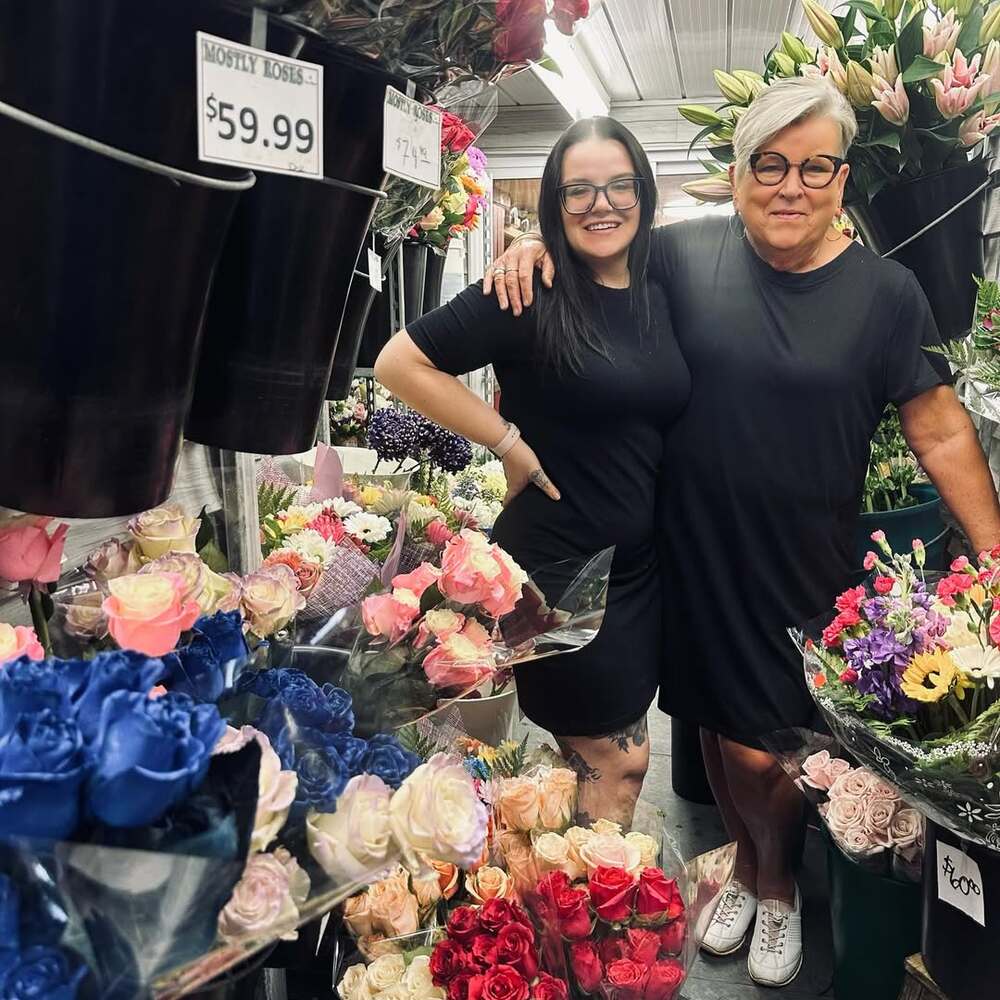 Florists smiling among colorful flower bouquets Florists smiling among colorful flower bouquets