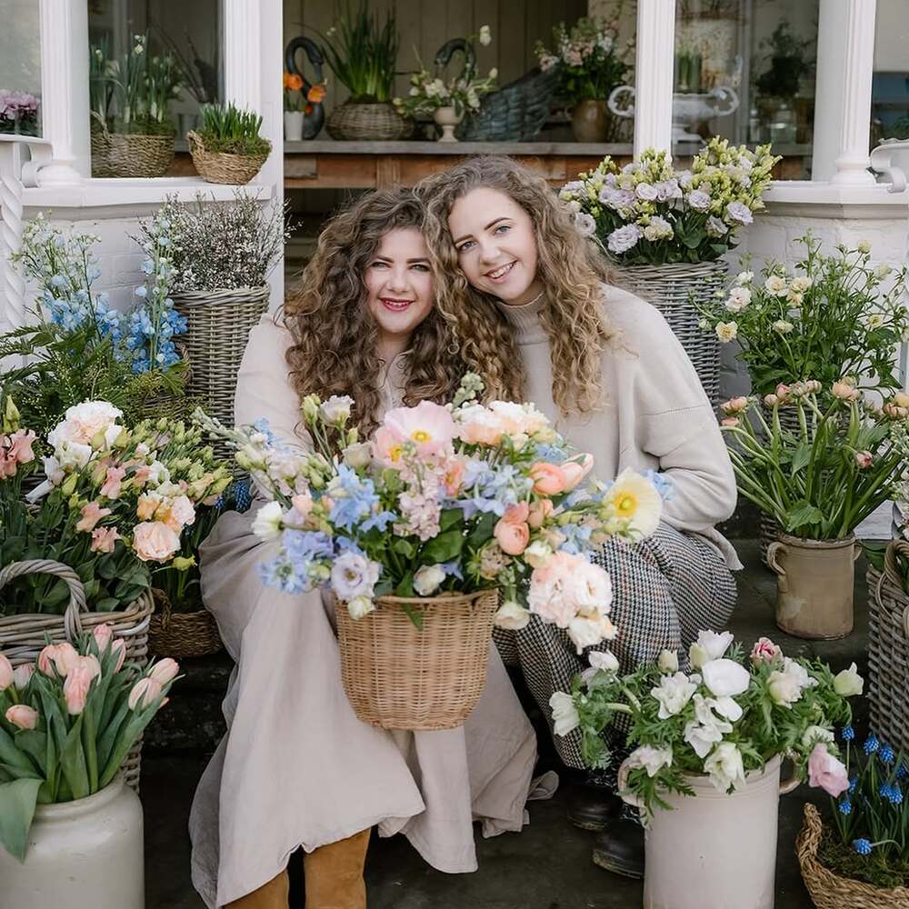 Florists posing with fresh flower baskets Florists posing with fresh flower baskets