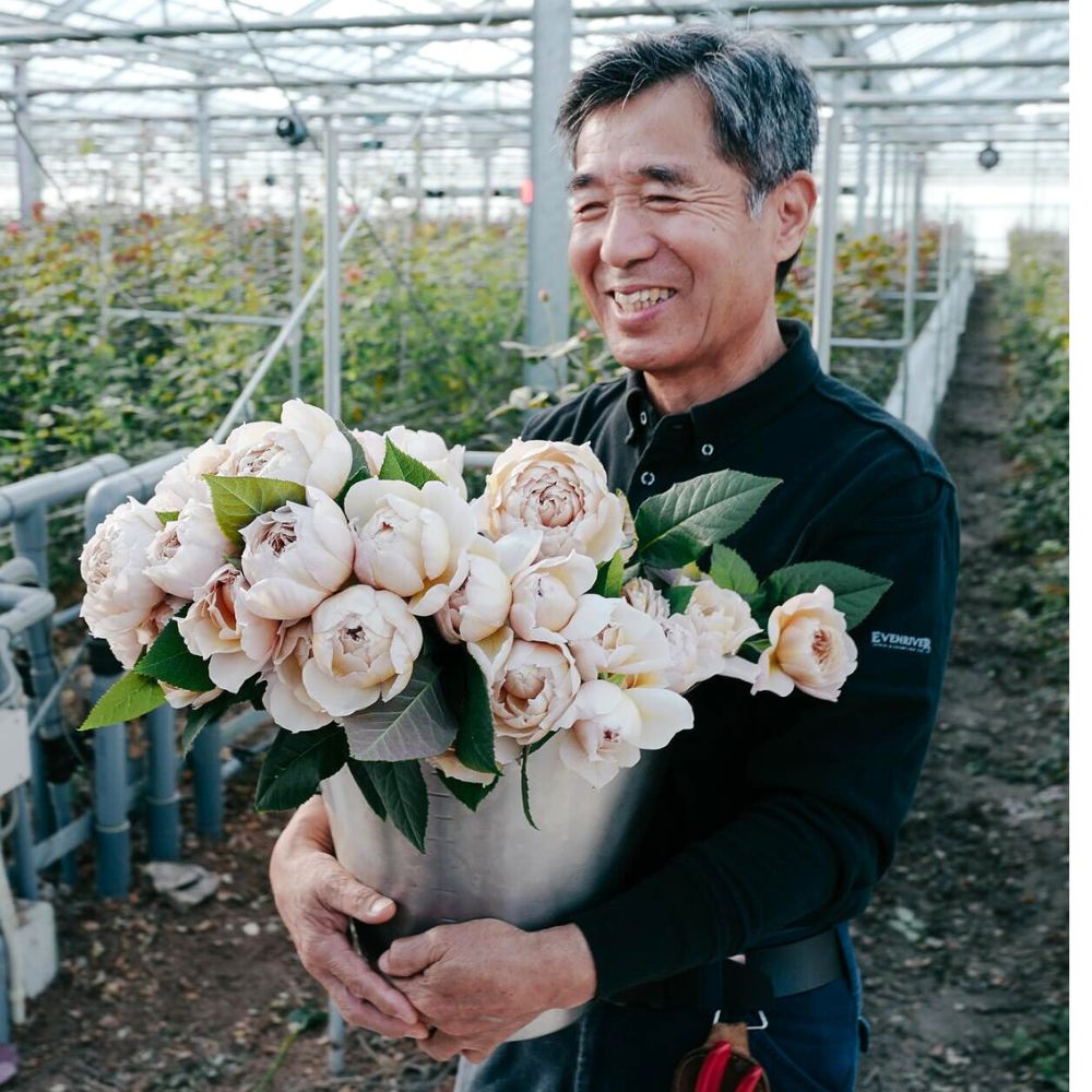 Breeder Keiji Kunieda holding a vase of Rose Charlotte Perriand Wabara Roses