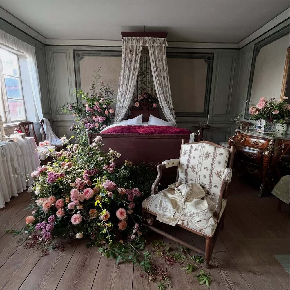 Floral installation beside canopy bed