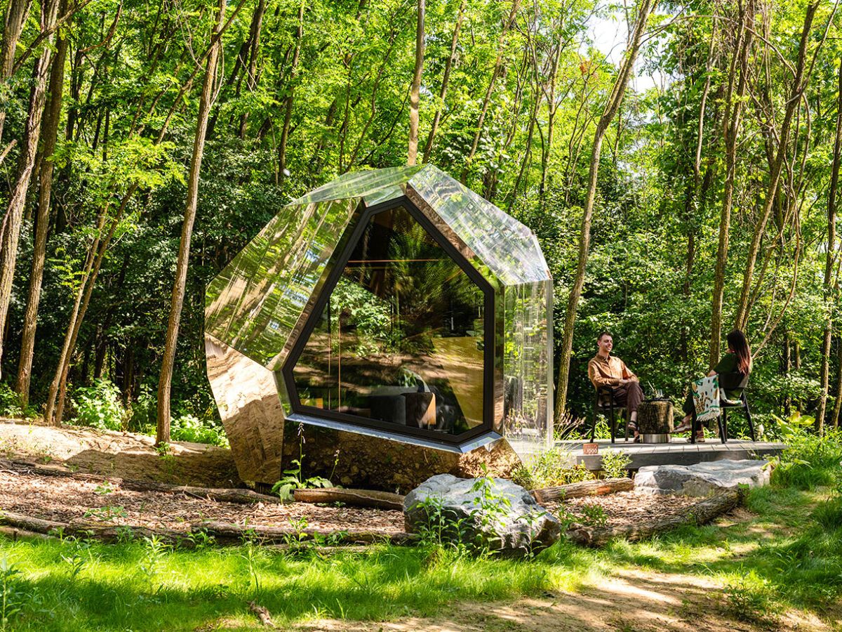 People sitting outside the timber cabin in nature