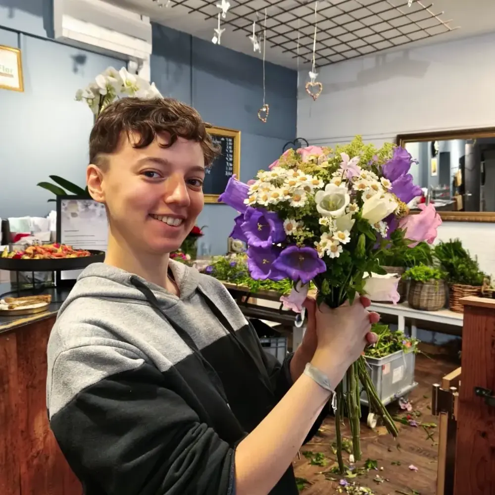 Smiling florist holding fresh bouquet Smiling florist holding fresh bouquet