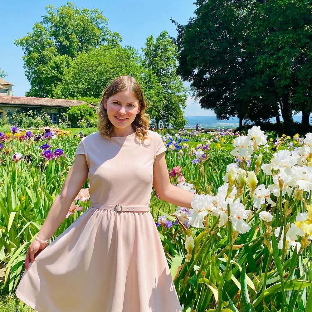 Smiling woman standing among blooms