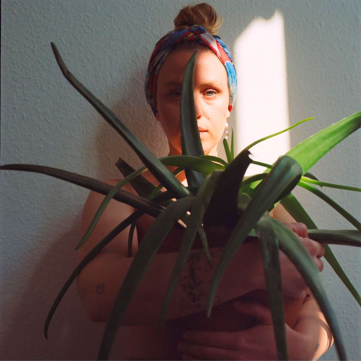 A girl smiling with a green plant