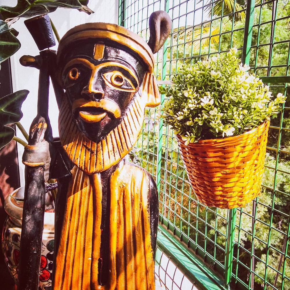 Wooden statue and plant on balcony Wooden statue and plant on balcony