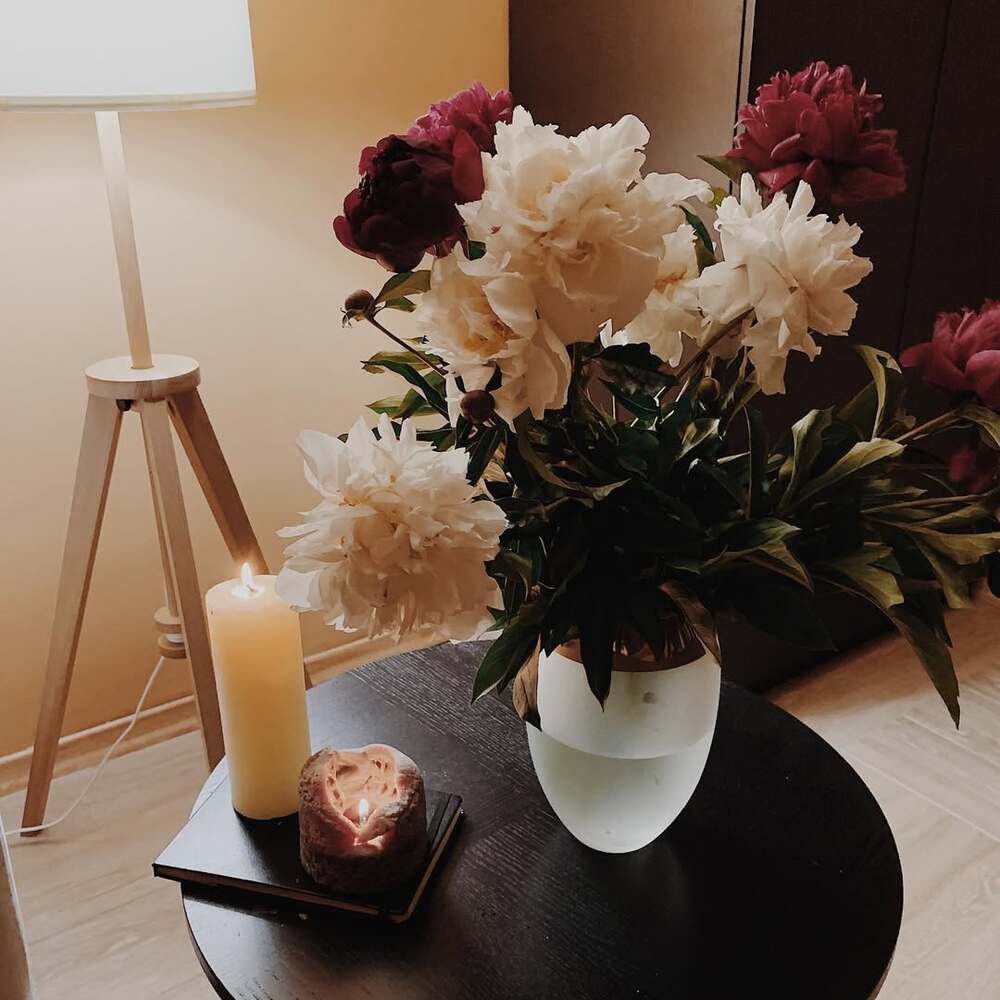 Peonies, candles, and lamp on table Peonies, candles, and lamp on table