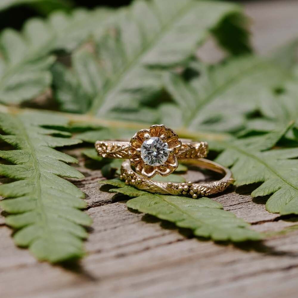 Flower-shaped engagement rings on fern Flower-shaped engagement rings on fern