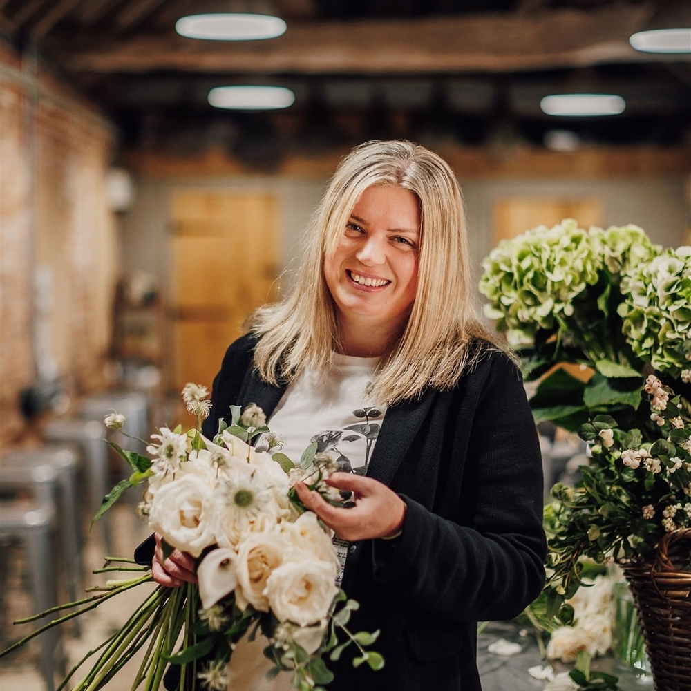 Florist smiling, holding white bouquet Florist smiling, holding white bouquet