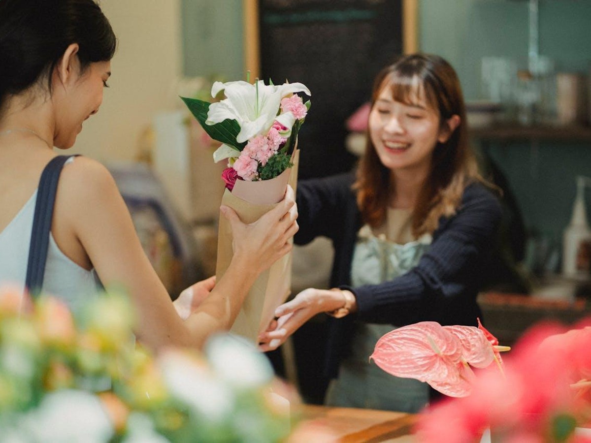 Florist hands customer flower bouquet.