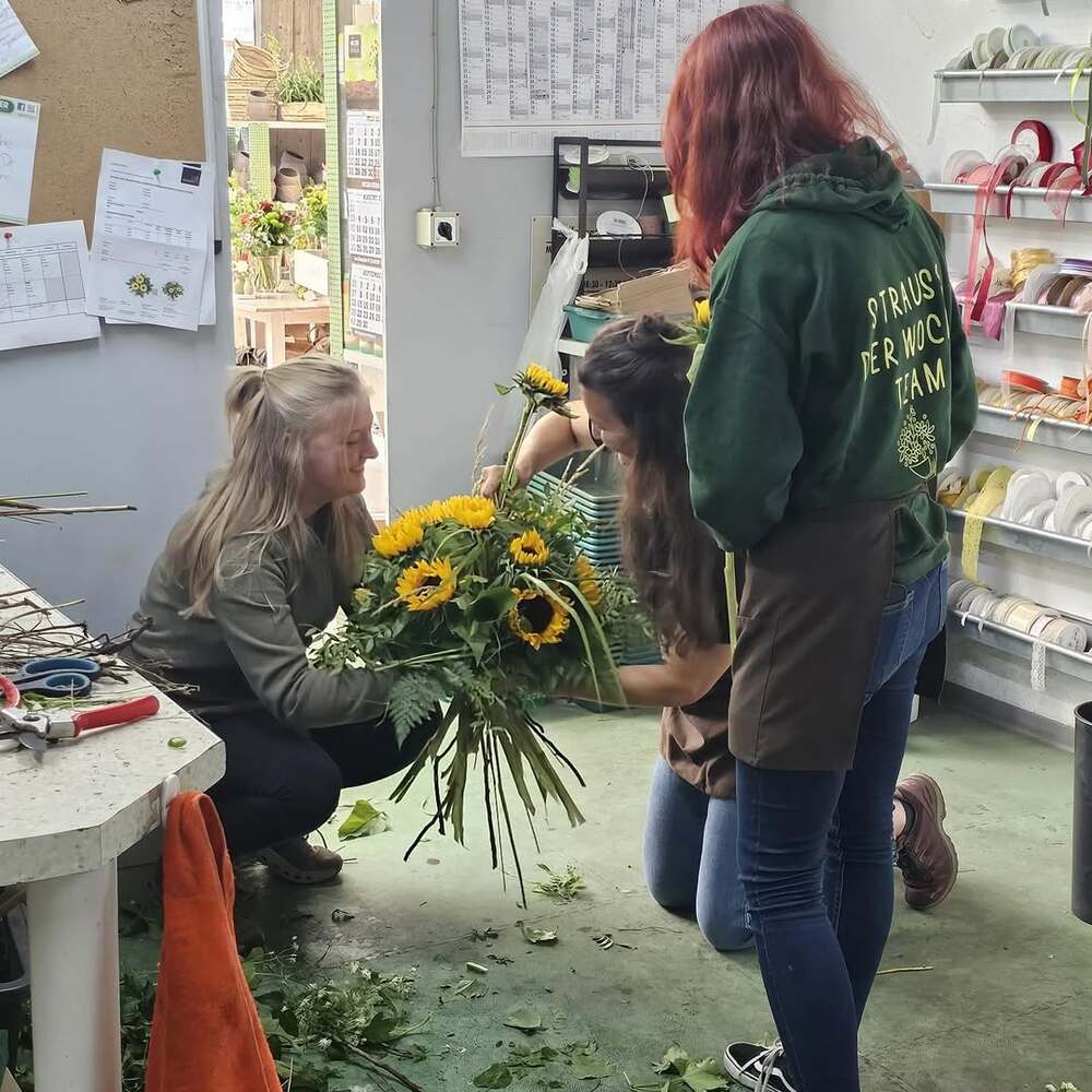 Three florists arranging large sunflowers Three florists arranging large sunflowers