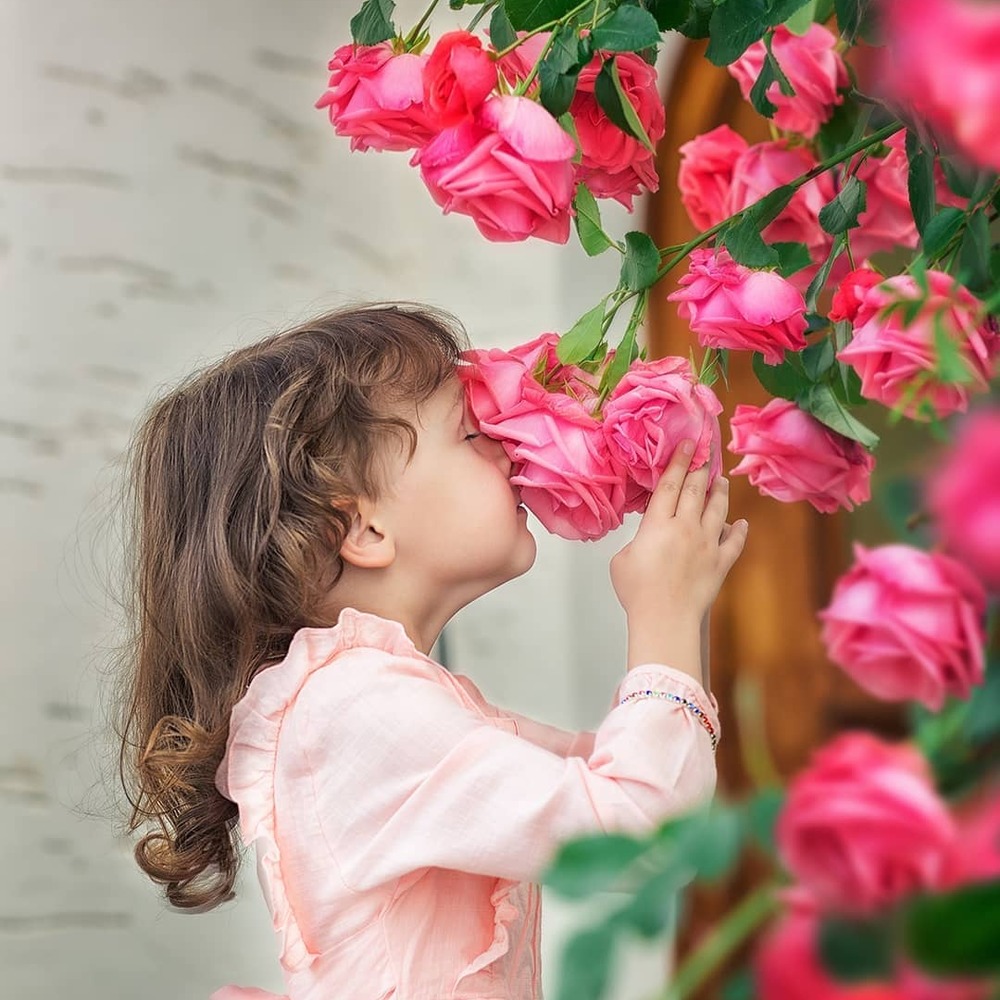 Girl smelling bright pink roses