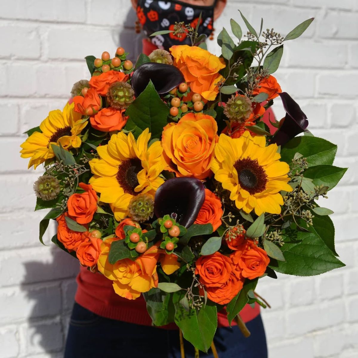 A mix of yellow and orange flowers with purple callas A mix of yellow and orange flowers with purple callas