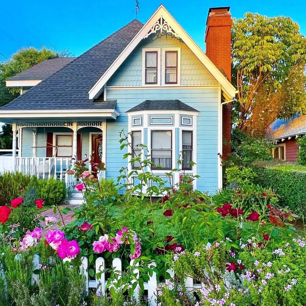 Victorian-style home with colorful flower garden Victorian-style home with colorful flower garden