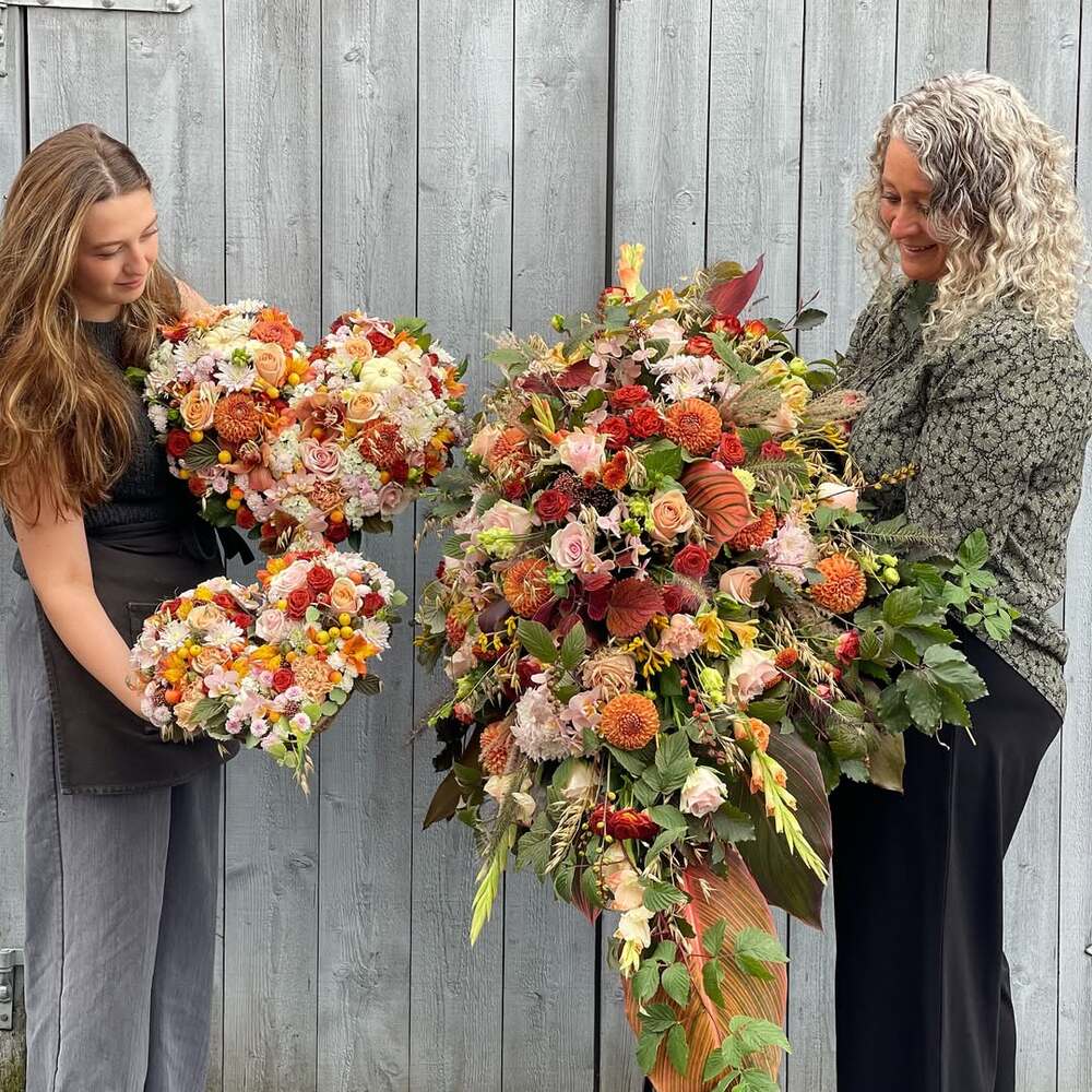 Florists with autumn funeral floral arrangements
