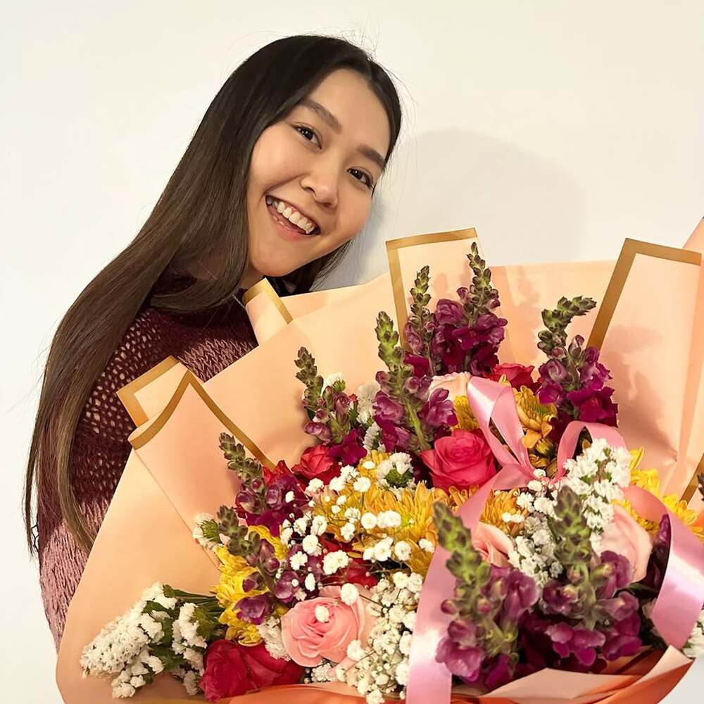 Smiling woman holding colorful flower bouquet