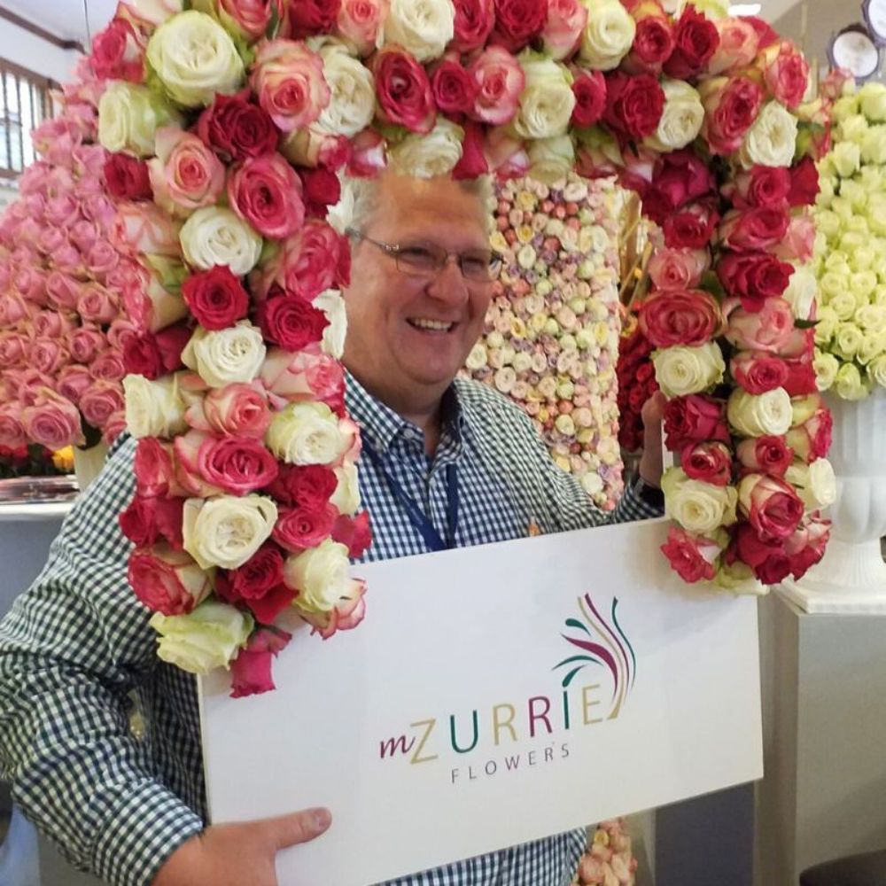 A client takes a picture at Mzurrie Flowers booth Mzurrie Flowers