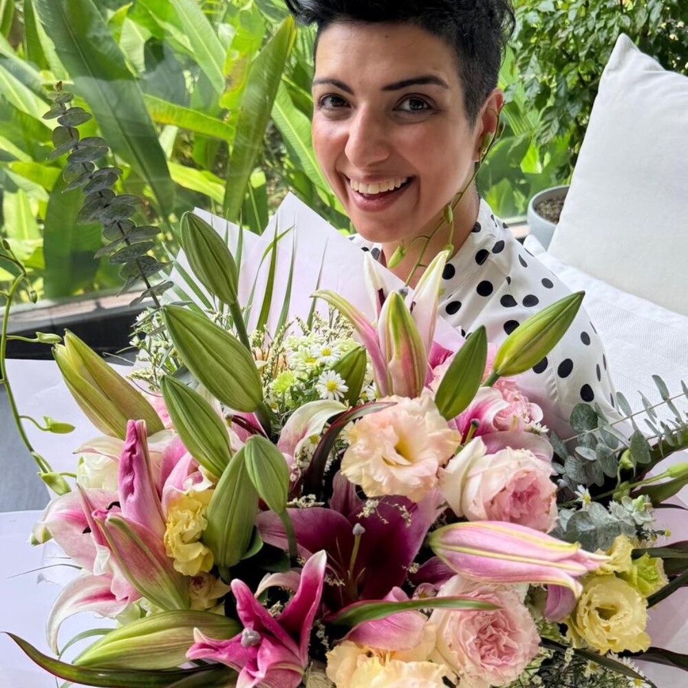 Woman holding large lily and rose bouquet Woman holding large lily and rose bouquet