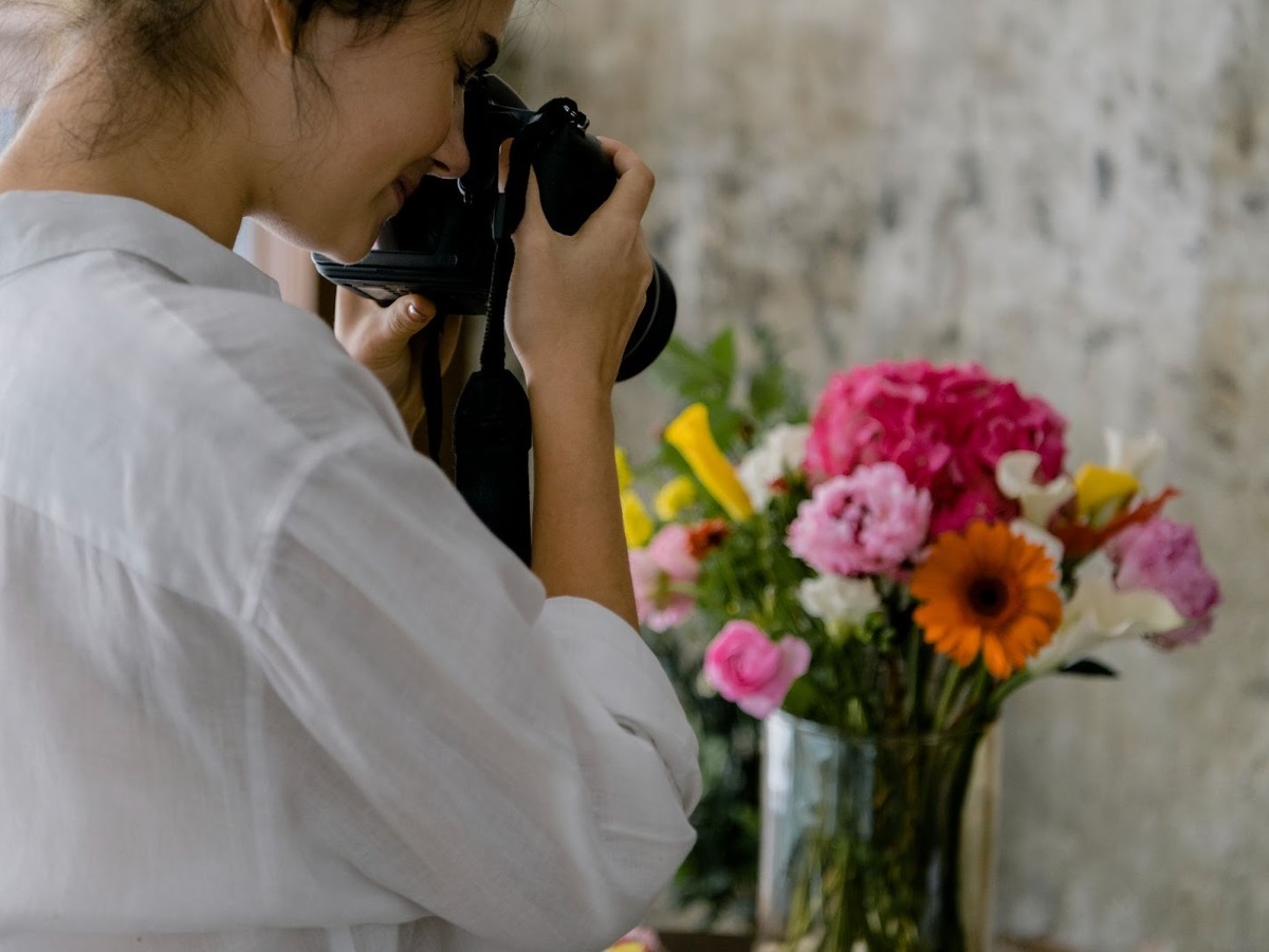 Woman Photographing Flowers with a Camera