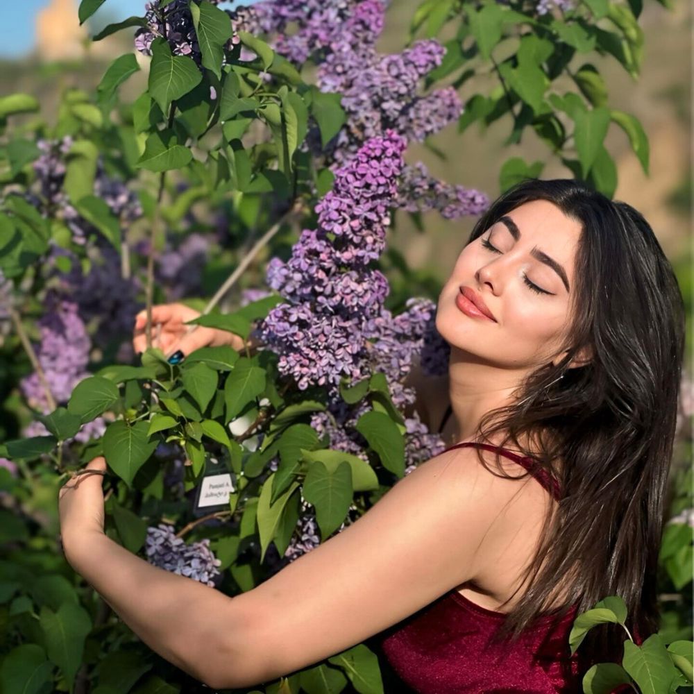 A lady soaking in the beauty and fragrance of Lilac flower