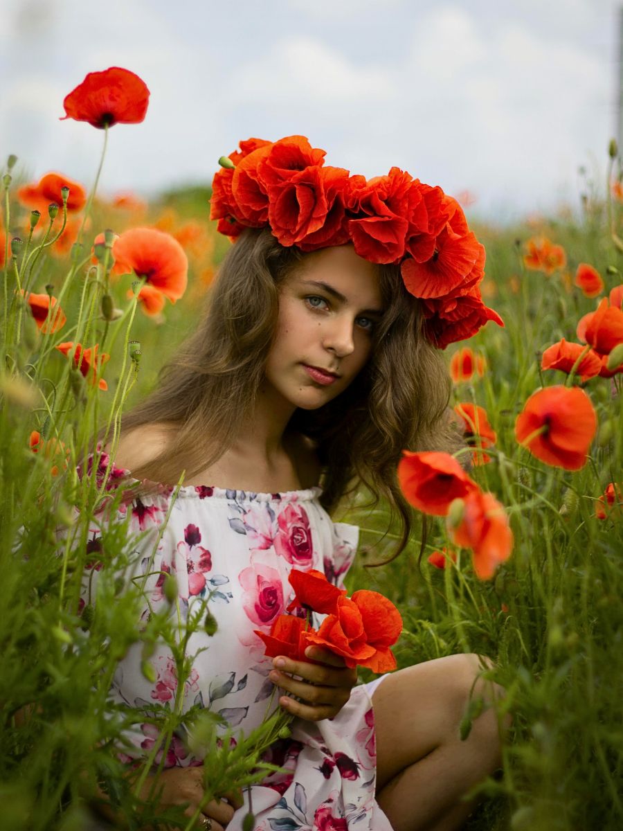 a model wearing head wreath made of poppy flowers