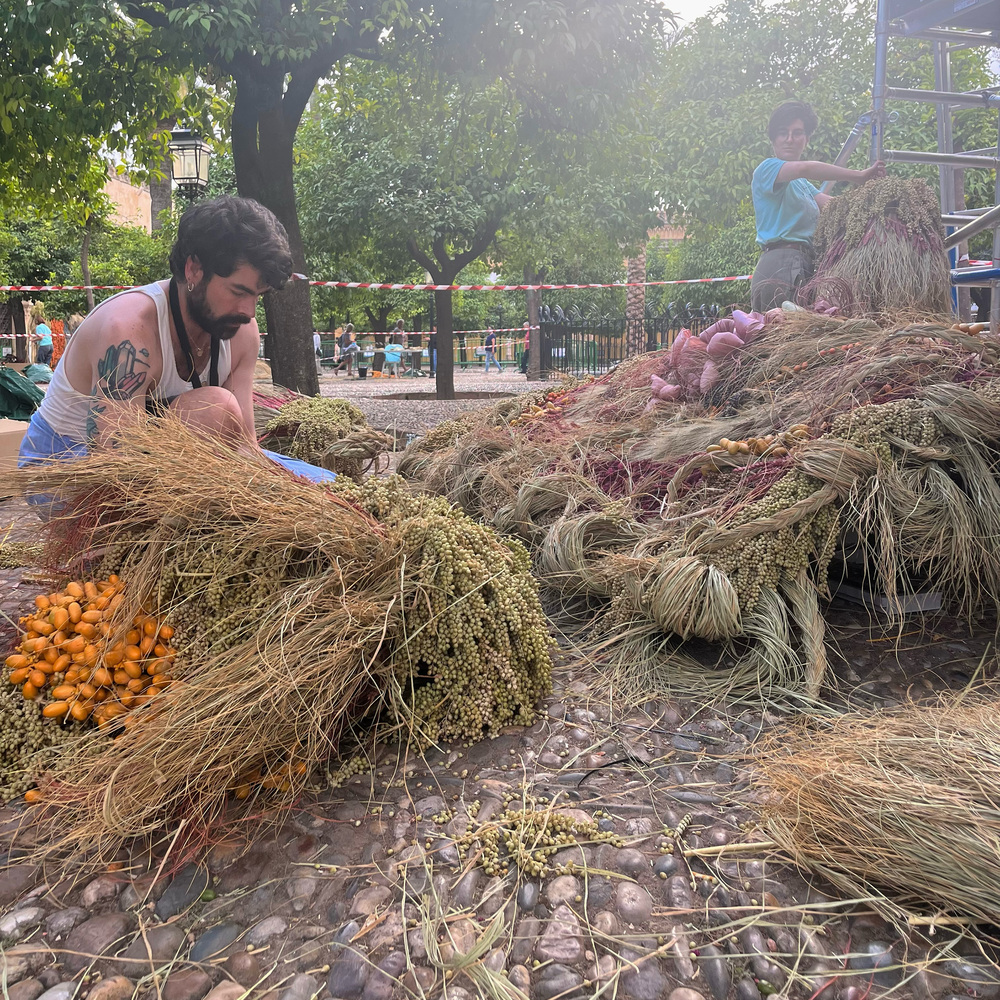 Artists weaving plant materials installation Artists weaving plant materials installation