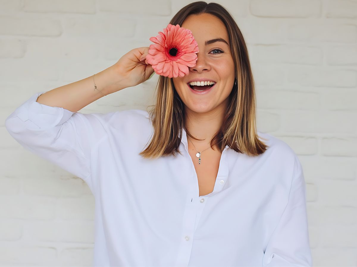 lady posing with a single gerbera stem in her hand